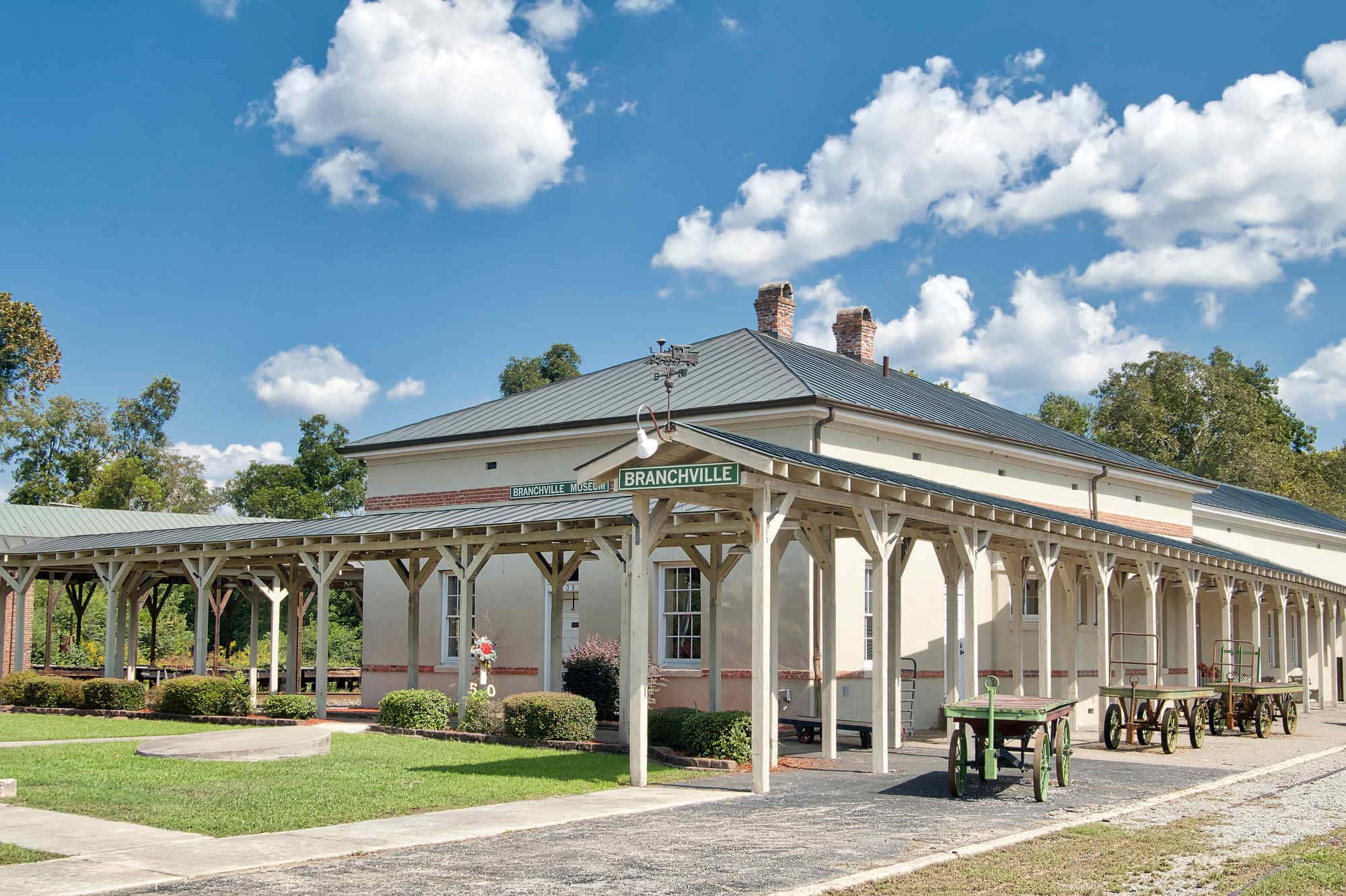 A one-story railroad depot with old fashioned covered area for loading passengers onto trains in Branchville, South Carolina.