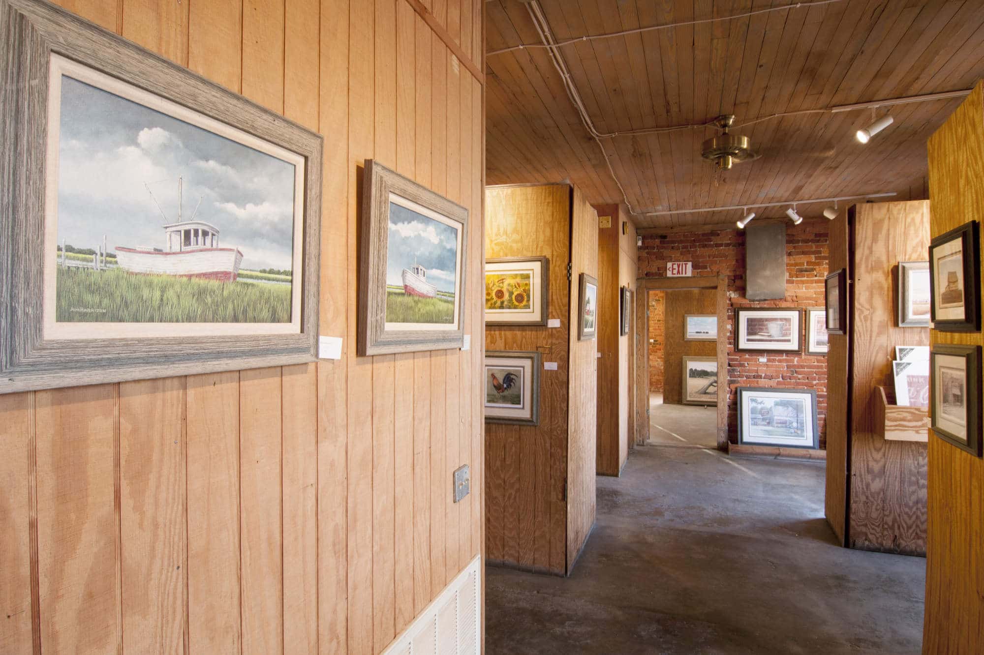 Paintings hang on the wood paneled walls at the Jim Harrison Gallery in Denmark, South Carolina.