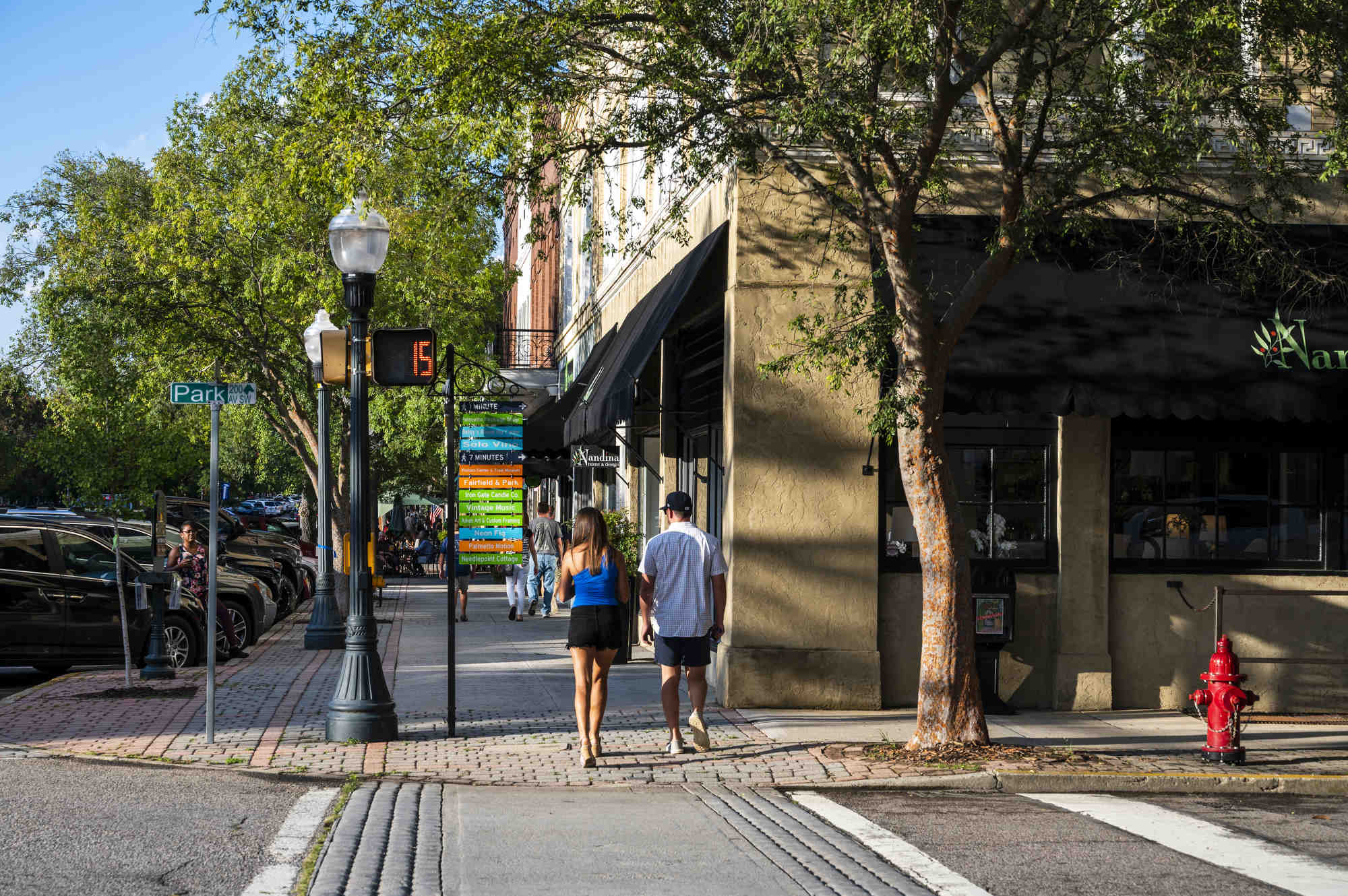 People wander along the sidewalks covered by shady trees in downtown Aiken, South Carolina.